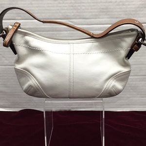 Leather Coach strapped cream colored handbag.